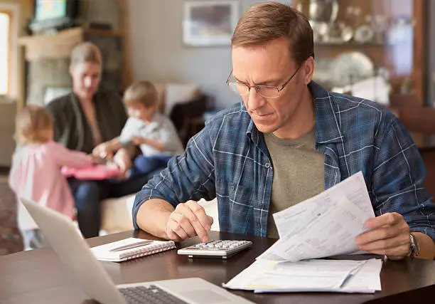 Pai de família fazendo contas e organizando o orçamento familiar