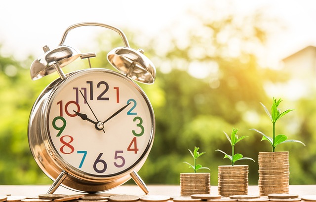 RELOGIO E MOEDAS REPRESENTANDO O EFEITO DO TEMPO AO INVESTIR O DINHEIRO DA RENDA EXTRA.